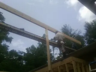 Carpenter setting a ridge beam over a new addition frame — Ice Dam Removal by Roofing Brothers in Boonton