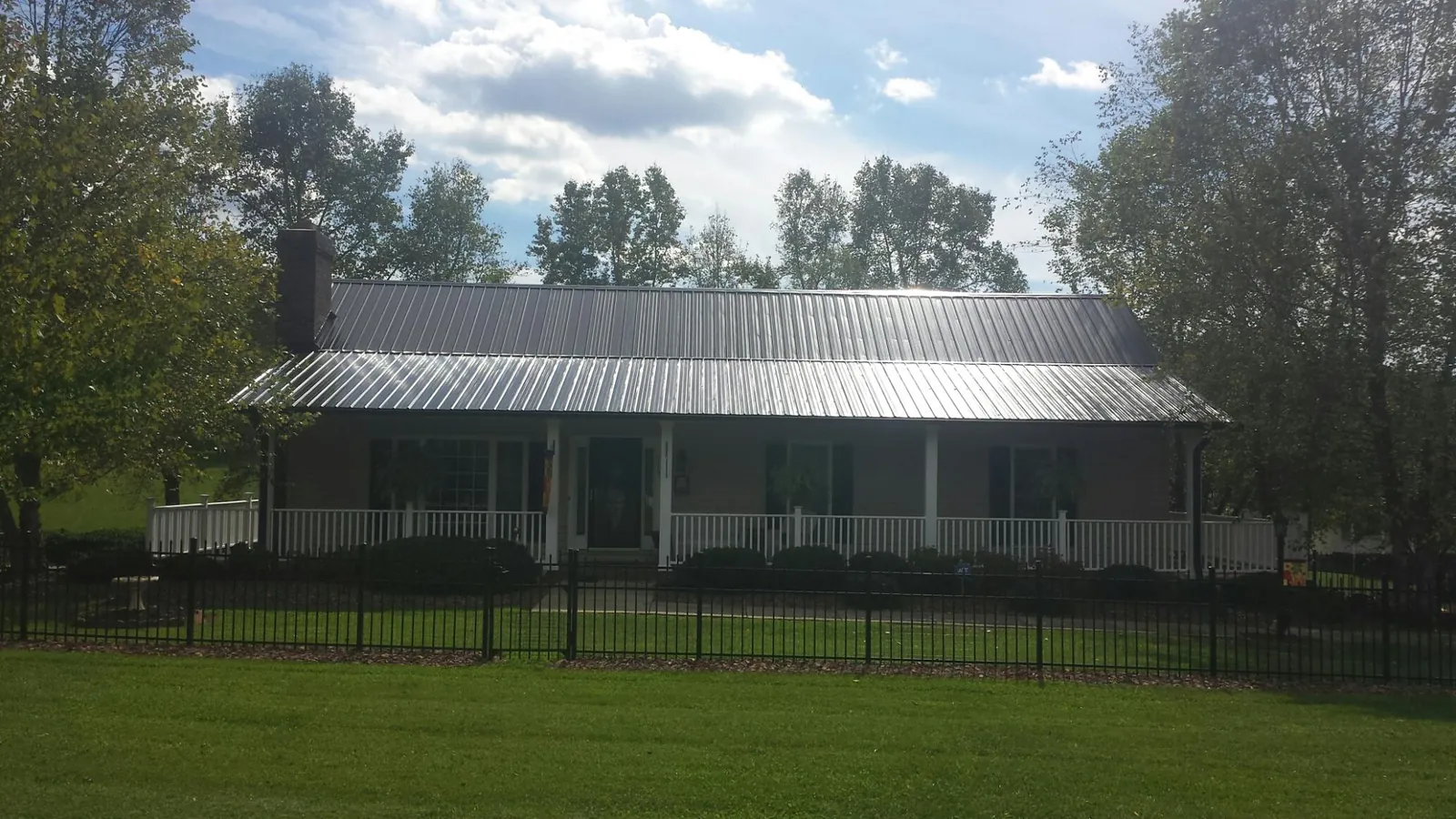 Gray metal roof on a brick ranch with a full width front porch — Gutter Guard Installation work by our crew in Boonton
